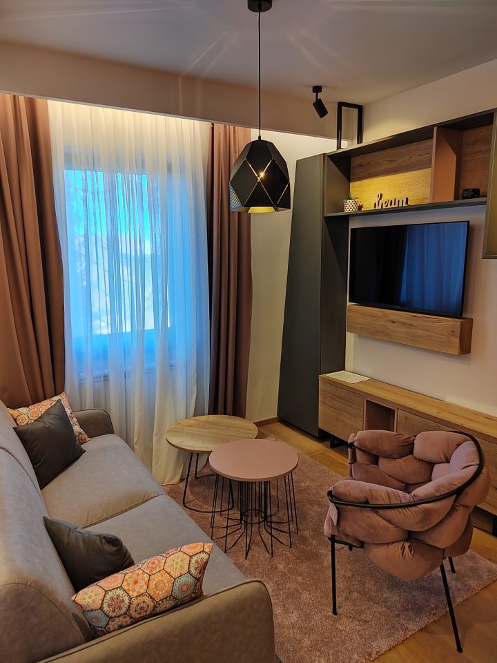 Sofa, stočići i TV zid sa policama