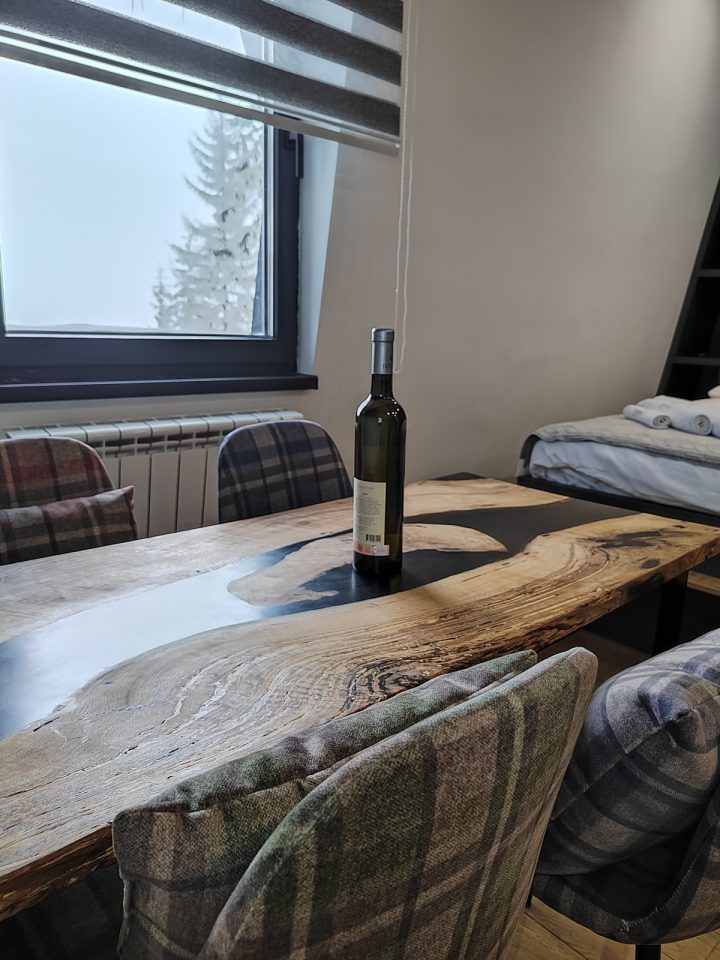 Trpezarijski sto uz prozor i karirane stolice