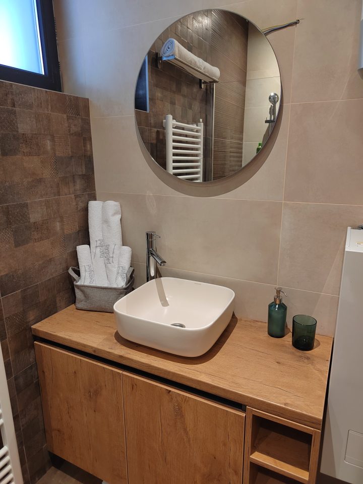Lavabo sa okruglim ogledalom i peškirima