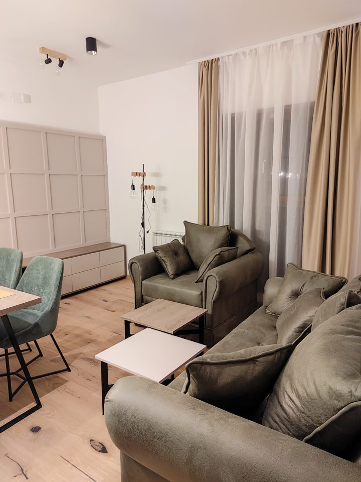 Fotelja, sofa i klub stočići kod prozora
